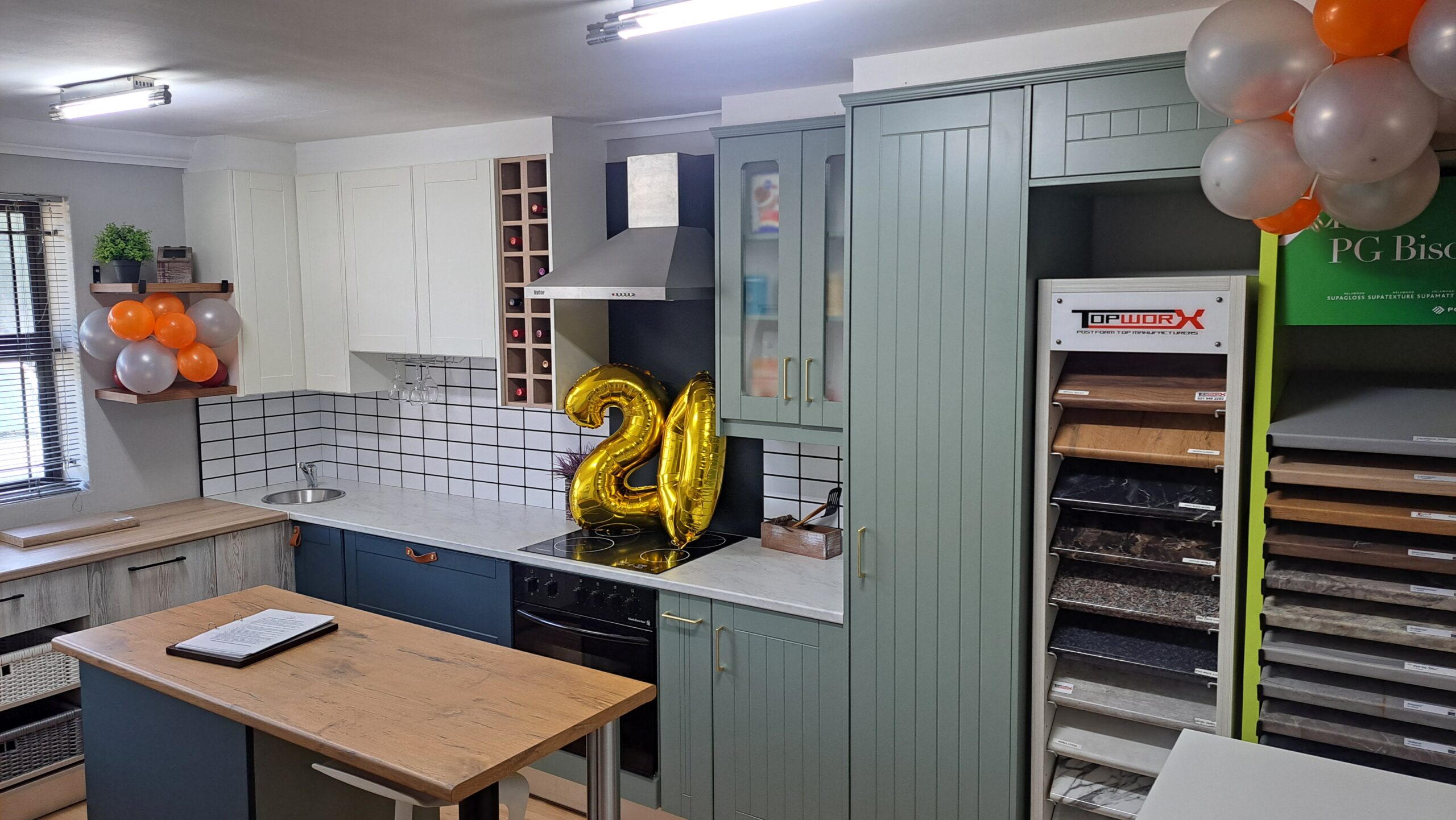 DIY Cupboards showroom kitchen with sage-green cabinets celebrating 20 years