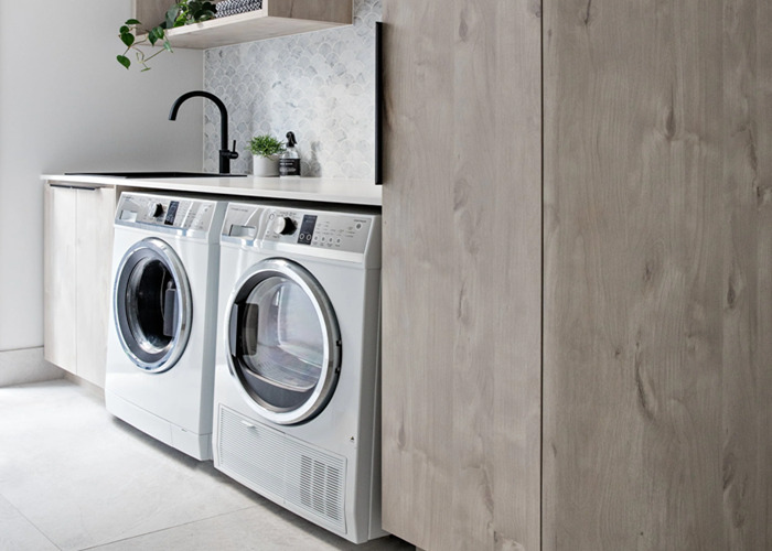 A tidy laundry area relies on cupboards that separate different jobs